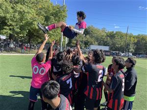 Large group of players toss their teammate into the air to celebrate.